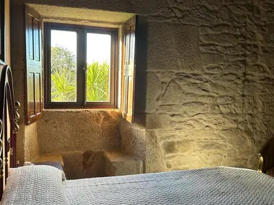 a bedroom with a bed and a window at Casal Rural Val Fresco - Casa Hórreo in Curantes