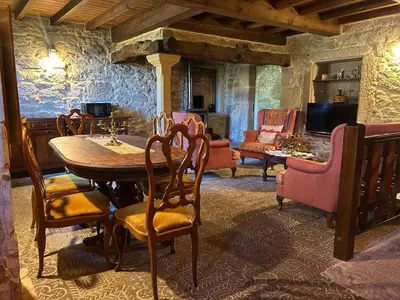 a dining room with a wooden table and chairs at Casal Rural Val Fresco - Casa Hórreo in Curantes