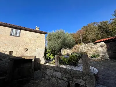 a stone house with a stone wall next to a building at Casa Rural Val Fresco - Casa Piano in Curantes