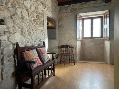 a room with a stone wall with a bed and a window at Casa Rural Val Fresco - Casa Piano in Curantes