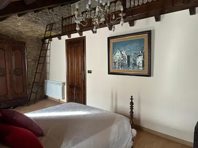 a bedroom with a bed and a painting on the wall at Casa Rural Val Fresco - Casa Piano in Curantes