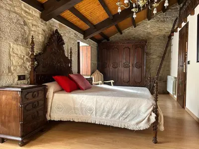 a bedroom with a bed and a wooden dresser at Casa Rural Val Fresco - Casa Piano in Curantes