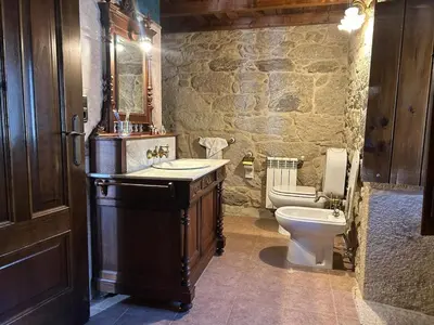 a stone bathroom with a sink and a toilet at Casa Rural Val Fresco - Casa Piano in Curantes
