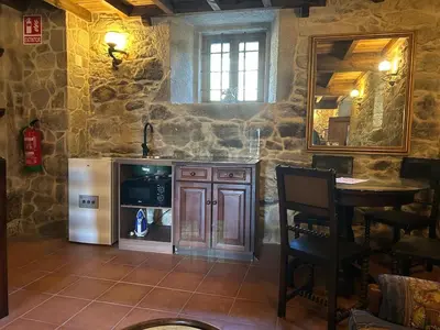 a kitchen with a refrigerator and a table and a mirror at Casa Rural Val Fresco - Casa Piano in Curantes