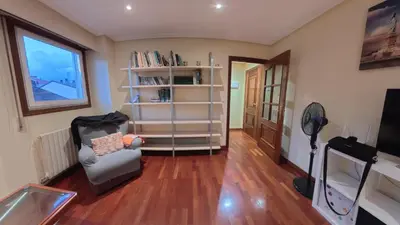 a living room with a chair and a book shelf at Mirador Residencia in Ourense
