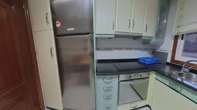 a kitchen with a stainless steel refrigerator and cabinets at Mirador Residencia in Ourense
