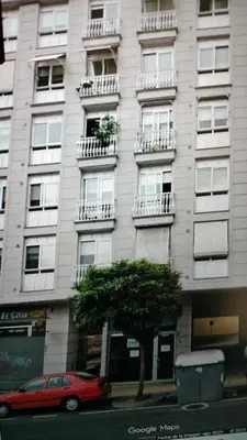 a red car parked in front of a building at Mirador Residencia in Ourense