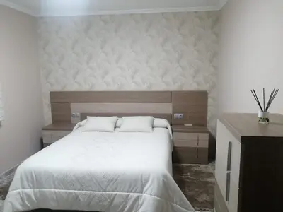 a bedroom with a large bed and a wooden headboard at Casa Castro in A Estrada