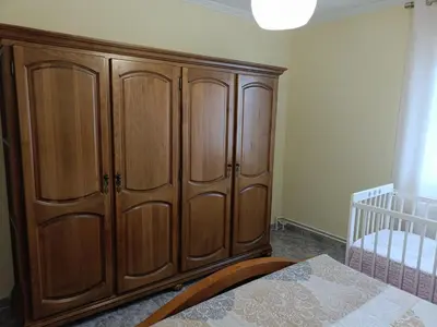 a large wooden cabinet in a bedroom with a crib at Casa Castro in A Estrada