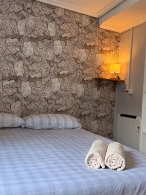 a bedroom with a bed with two towels on it at A Casiña de Coles in Gustey
