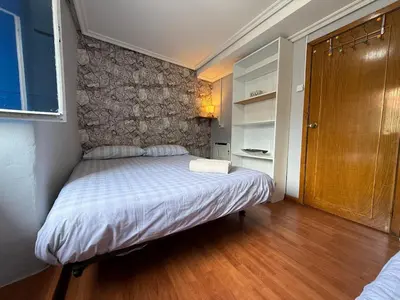 a small bedroom with a bed with a stone wall at A Casiña de Coles in Gustey