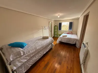 a bedroom with two beds and a window at A Casiña de Coles in Gustey