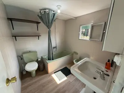 a bathroom with a tub and a toilet and a sink at A Casiña de Coles in Gustey