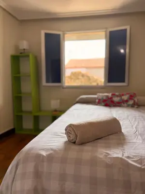 a bedroom with a bed with a towel on it at A Casiña de Coles in Gustey