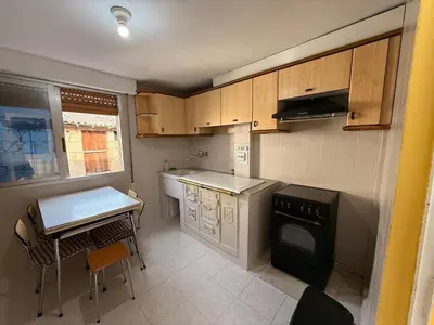 a small kitchen with a table and a stove at A Casiña de Coles in Gustey