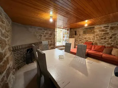 a dining room with a table and a couch at A Casiña de Coles in Gustey