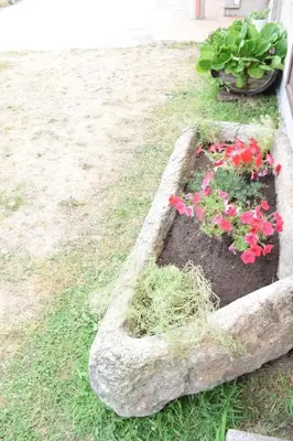 a garden with pink flowers in a stone planter at Casa Requias in Requiás