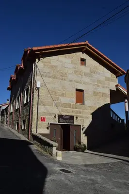 a large brick building with a garage in front of it at Casa Requias in Requiás