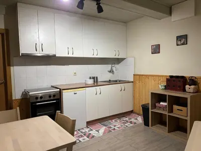 a kitchen with white cabinets and a table in it at O lar do Arroio in Allariz