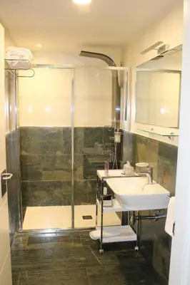 a hotel room with a bed and a chair at Albergue Guiana in Ponferrada
