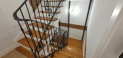 a spiral staircase in a room with wooden floors at El Sueño in Barres