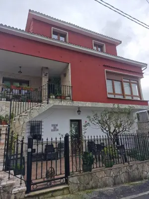 a red and white house with a black fence at Fogar do Gabino in Padrón
