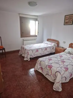 a room with three beds and a window at Fogar do Gabino in Padrón