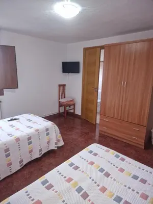 a hotel room with two beds and a closet at Fogar do Gabino in Padrón