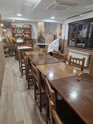 a restaurant with wooden tables and chairs and a fireplace at Fogar do Gabino in Padrón