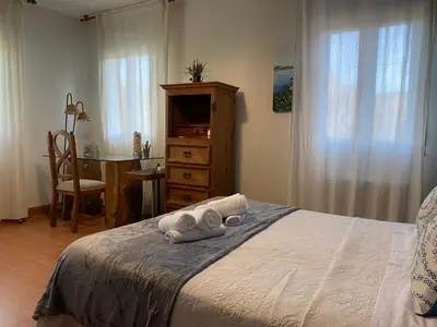 a bedroom with a bed with a desk and a chair at Casa Rosiña in Campo Lameiro