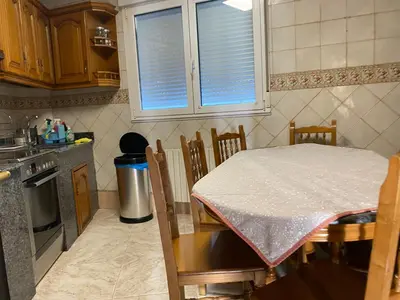 a kitchen with a table and a table and chairs at Casa Rosiña in Campo Lameiro