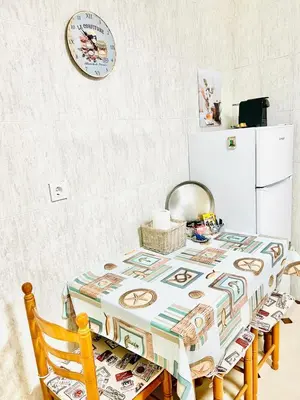 a table with a table cloth on it with a refrigerator at Tineo centro in Tineo