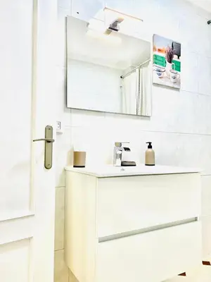 a white bathroom with a sink and a mirror at Tineo centro in Tineo
