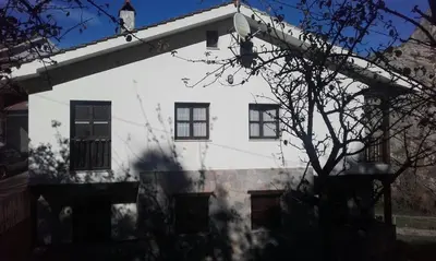 a white house with windows and a tree at El Mirador Del Parque in Gúa
