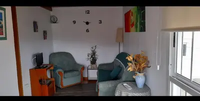 a living room with two chairs and a tv at Casa da Tita