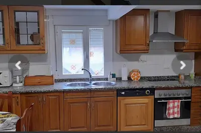 a kitchen with wooden cabinets and a sink and a window at Casa da Tita