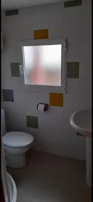 a bathroom with a toilet and a sink and a window at Casa da Tita