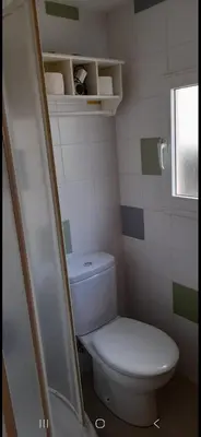 a small bathroom with a toilet and a window at Casa da Tita
