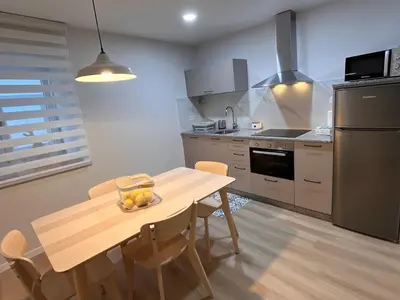 a kitchen with a wooden table with a bowl of fruit on it at Valdeflores Flats Bj in Viveiro