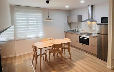 a kitchen with a table and chairs in a room at Valdeflores Flats Bj in Viveiro