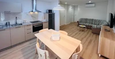 a kitchen and living room with a table and a couch at Valdeflores Flats Bj in Viveiro