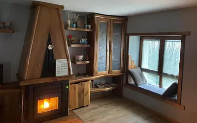 a living room with a fireplace and a window at Vivienda turística en plena naturaleza O Poleiro