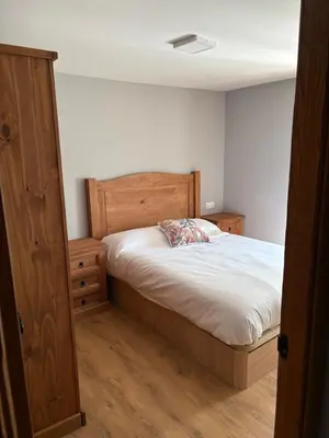 a bedroom with a bed with a wooden headboard at Vivienda turística en plena naturaleza O Poleiro