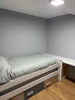 a bed in a room with a white wall at Vivienda turística en plena naturaleza O Poleiro