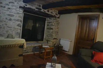 a living room with a couch and a stone wall at La Casa de Rosa in Filiel