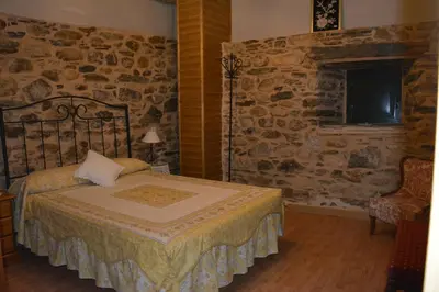 a bedroom with a bed and a stone wall at La Casa de Rosa in Filiel