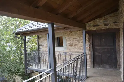 a porch of a stone house with a wooden door at La Casa de Rosa in Filiel