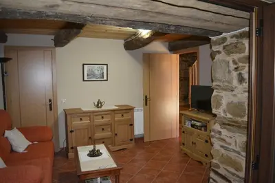 a living room with a couch and a stone wall at La Casa de Rosa in Filiel