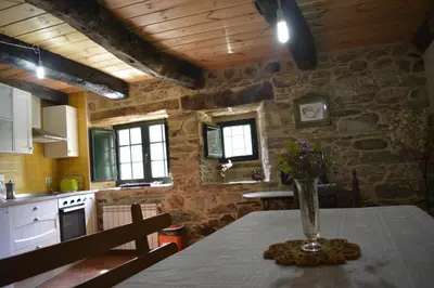 a kitchen with a table with a vase of flowers on it at La Casa de Rosa in Filiel