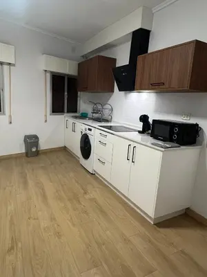 a kitchen with white cabinets and a washer at Casco histórico Allariz-Iria in Allariz